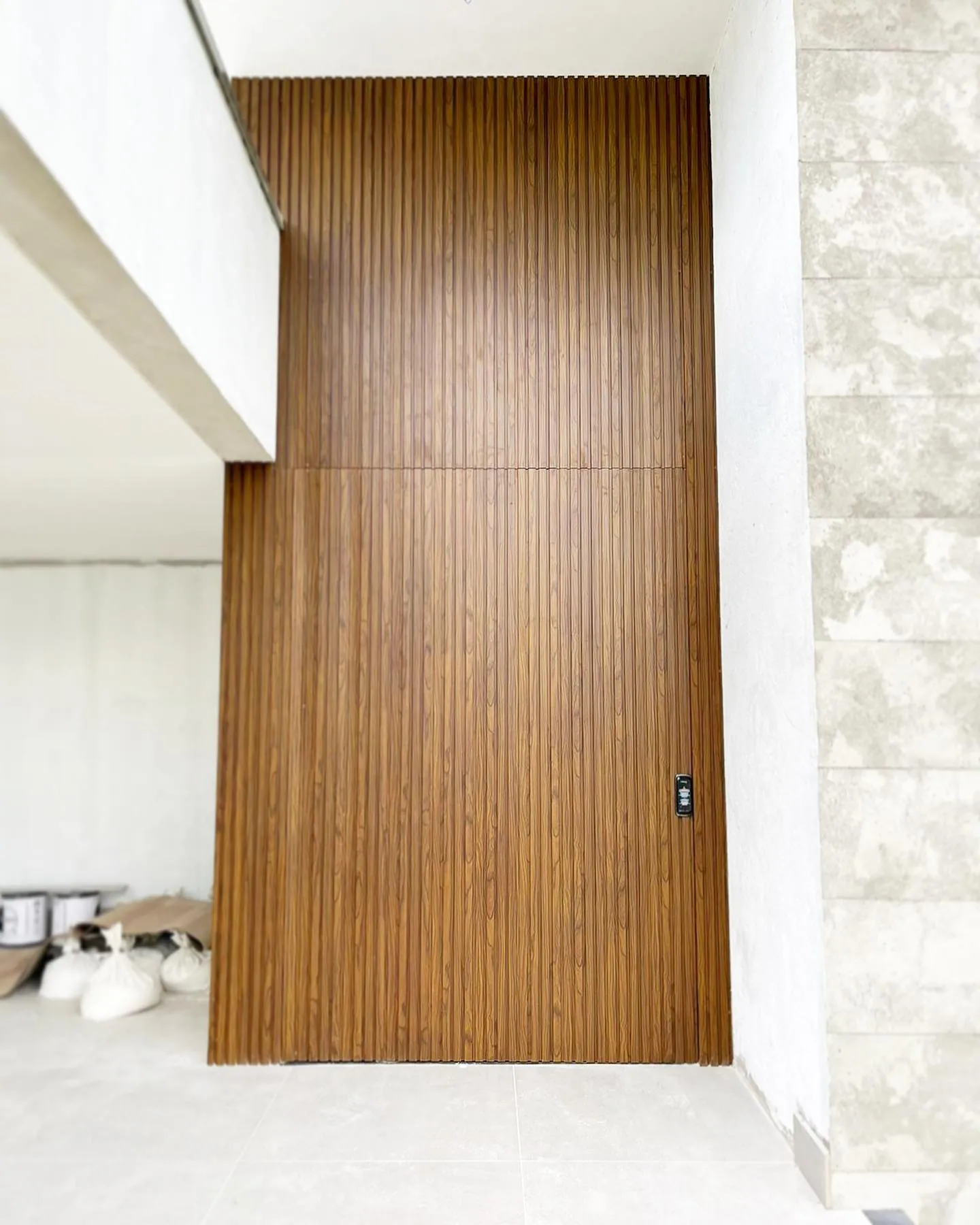 Entrada residencial com porta de acabamento amadeirado